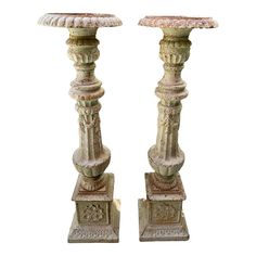 two large stone candlesticks are standing next to each other