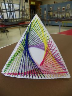 a triangle made out of colored paper on top of a table