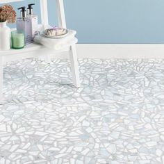 a bathroom with blue walls and white flooring has a mosaic tile pattern on the floor