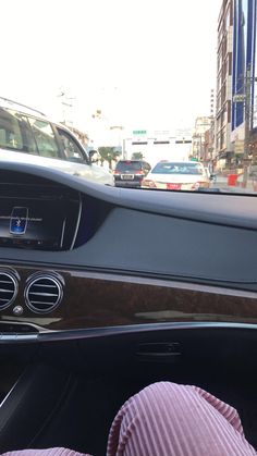 the dashboard of a car with cars driving on it's sides and buildings in the background