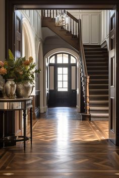 an entry way with stairs and vases filled with flowers