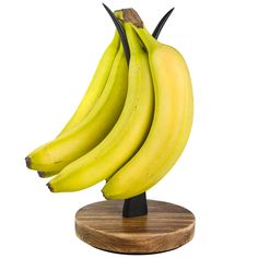 a bunch of bananas sitting on top of a wooden stand in front of a white background