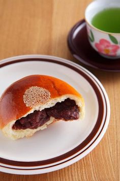 a piece of food on a plate next to a cup of green tea