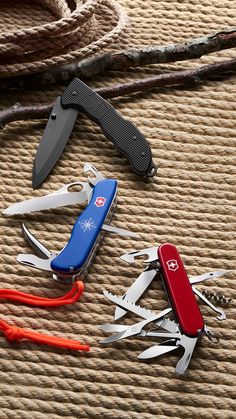 several swiss army knifes are laying on the floor next to each other and one is open