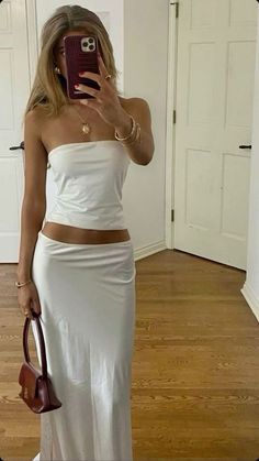 This minimalist all-white ensemble is perfect for a breezy, sophisticated summer look. Featuring a strapless tube top and a flowing maxi skirt, the outfit combines effortless style with a touch of elegance. The look is accessorized with gold jewelry, including a statement sun pendant, and completed with a sleek burgundy handbag for a pop of color. Ideal for a warm evening out or a casual day event. #SummerFashion #MinimalistStyle #AllWhiteOutfit #ChicLook #FashionInspo Maxi Skirt Outfit Summer, Not Worth It, Fashion Mistakes, Going Out Outfits, 10 Pounds, Fashion Aesthetic, Looks Style, Spring Summer Outfits, Fashion Killa