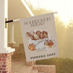 there is a sign that says sourdough bread hanging from the side of a building