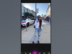 a woman is taking a selfie on her cell phone in the middle of the street