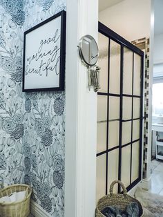 a bathroom with blue and white wallpaper has a basket on the floor next to it