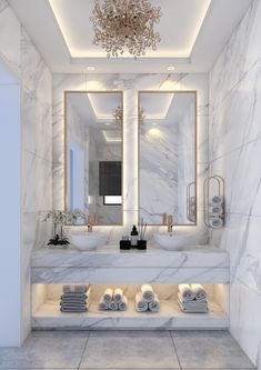 a bathroom with marble walls and flooring is shown in this image, there are towels on the counter