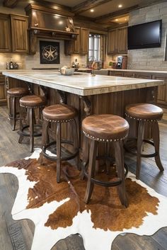 a kitchen island with stools and a cow hide rug on the floor in front of it