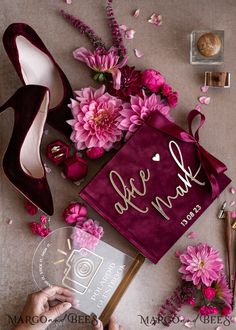 a graduation cap with flowers and shoes on the table next to it is a bouquet of pink peonies