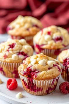 several raspberry muffins on a white plate