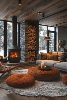 a living room filled with furniture and a fire place in the middle of it on top of a wooden floor