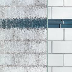 a shower head with water running down it's side and the wall behind it