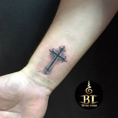 a small cross tattoo on the wrist