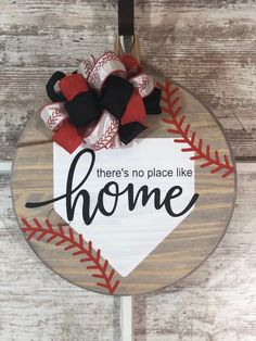 there's no place like home sign on a baseball ornament hanging from a door