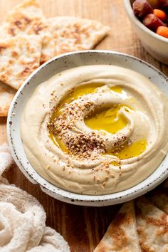 hummus with olives and pita bread on the side, ready to be eaten