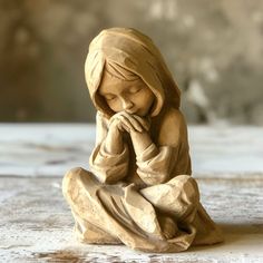 a statue of a child praying on a table