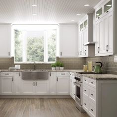 a large kitchen with white cabinets and green walls, wood flooring and counter tops