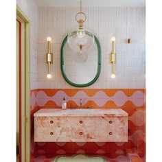 a bathroom with an oval mirror above the sink and marble counter top on the wall