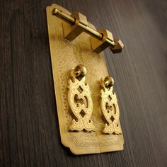 pair of gold plated earrings sitting on wooden table next to metal clippings