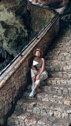 a woman sitting on some steps next to the ocean