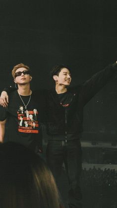 two young men standing next to each other at a concert