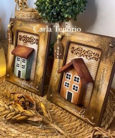 there are two frames with small houses on them, one is painted gold and the other is brown