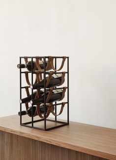 a wooden table topped with a wine rack filled with bottles