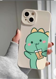 a person holding up a phone case with a cat on it's back and a drink in the other hand