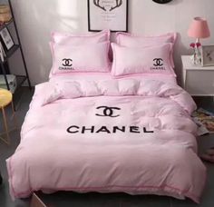 a pink bed with chanel logo on the comforter and matching pillowcases