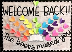 a welcome back sign with hearts coming out of it and an open book in the middle