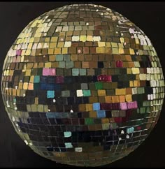 a disco ball with many different colored tiles on it's side and black background