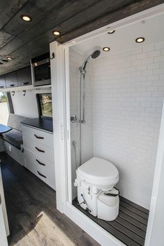 a white toilet sitting inside of a bathroom next to a walk - in shower and sink