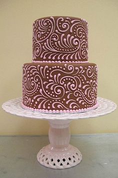 a three layer chocolate cake with pink icing