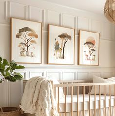 a baby's room with three pictures hanging on the wall and a crib