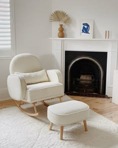 a white living room with a fireplace and rocking chair