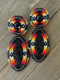 three pieces of beaded jewelry sitting on top of a wooden floor