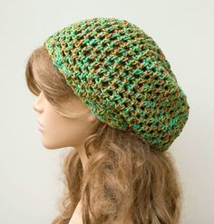 a mannequin head wearing a green and brown crochet knitted hat