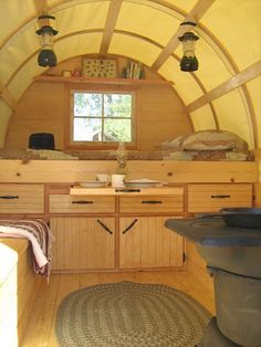 the inside of a tiny house with wood floors and walls, including a stove top oven