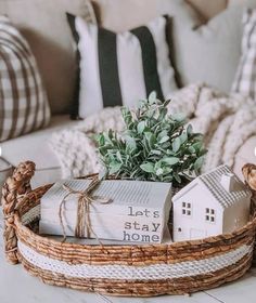 a wicker basket filled with books on top of a table next to a couch