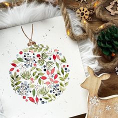 a christmas ornament on a card surrounded by other holiday decorations