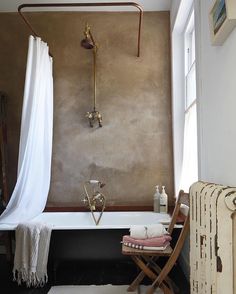 a bathroom with a tub, towel rack and radiator