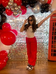 a woman standing in front of balloons with her arms up