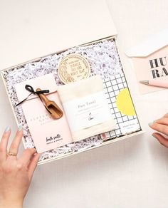 a woman's hands holding a box with some items in it