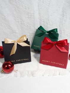 three christmas gift boxes with bows and ornaments