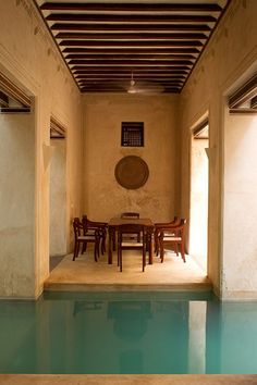 an indoor swimming pool with tables and chairs