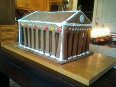 a large cake shaped like a house on top of a wooden table in a kitchen