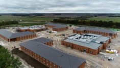 an aerial view of a building being built in the middle of a field with trees