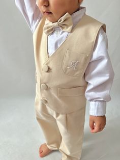 ✿ABOUT THIS SUİT ✓Our handmade 5-piece set featuring a baby boy ecru suspender pants, hat, bow tie, vest, and white shirt. ✓Our suit is made from a luxurious blend of cotton and silk alpaca fabric. ✓The suit is available in a range of color options to suit any style or preference.  ✓The vest can even be personalized with letter embroidery upon request, making it a truly one-of-a-kind piece. ✓The trousers feature elastic at the back, ensuring a comfortable fit, while the straps can be adjusted in Fitted Beige Cotton Sets, Fitted Cotton Off White Sets, Fitted Cotton Sets In Off White, Fitted Beige Sets For Baptism, Cream Cotton Sets For Baptism, Classic Cotton Beige Set, Classic Beige Cotton Set, Fitted Embroidered Beige Sets, Elegant Sleeveless Cotton Sets